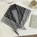 Vista detallada de un elegante pañuelo triangular de lunares en blanco y negro con borde geométrico. - Patchwork Lunares Rayas Retro / 130*65cm