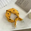 Gros plan d'un petit foulard a pois en coton jaune, noue proprement sur un fond blanc pur. - 55*55CM / Orange