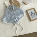 Lichtblauwe geborduurde driehoekige sjaal met witte pom-pom kantrand en strikbanden. - Eén maat / Blauw