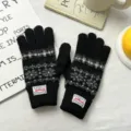 Detailed view of black knit winter gloves with classic fair isle pattern and cuff label. - 24*7cm / Black