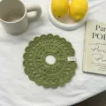 Primo piano dettagliato di un elastico per capelli verde lavorato all'uncinetto con pizzo. - Verde