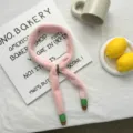 Close-up detail of soft pink plush narrow scarf with cute cactus pendants, cozy accessory. - 45x4cm / Pink