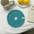 Dettaglio scrunchie per capelli in fettuccia turchese lavorata all'uncinetto, elegante design traforato. - Blu
