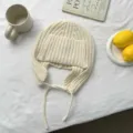 Cómodo gorro trapper de punto en color crudo con orejeras y cordones para otoño e invierno. - Talla única / Blanco