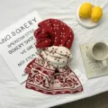 Close-up detail of the red and white knitted winter scarf featuring festive snowflake patterns. - 166*30cm / Red