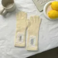 Detailed view of cream knitted full-finger gloves with white lace patches and cuffs. - 29*8.5cm / Yellow