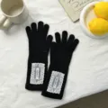 Detail view of black knitted gloves with elegant white lace patches, cozy autumn winter gear. - 29*8.5cm / Black