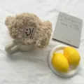 Flauschige beige Winter-Ohrwärmer im Detail, weiche Plüschtextur und süßes Design mit Lächeln-Label. - Einheitsgröße / Khaki