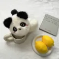 Vue détaillée de charmantes oreillettes panda en peluche dans un décor chaleureux. - Taille unique / Panda Malin