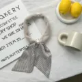 Soft plush neckerchief with pearl magnetic buckle and chic striped ribbon ends detail. - Striped Style