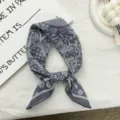 Primer plano detallado del pañuelo cuadrado gris retro con delicados motivos de pájaros. - 56*56cm / Azul grisáceo