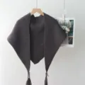Details van gebreide driehoekige sjaal, donkerbruine franje omslagdoek, modieus accessoire. - Grijs
