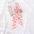 Detalle de primer plano de una bufanda de cinta de gasa con estampado de cerezas, accesorio chic. - 95cm*6cm / Manzana Roja
