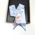 Vue détaillée d'un foulard en soie bleu clair avec fleurs, ruban élégant pour sac. - 130cmx6cm / Style 02 (Bleu Clair Fleur Rose)