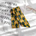 Vue détaillée du foulard en coton imprimé jaune, idéal pour les sacs et le cou. - Base Jaune Plante Verte Vintage (Style 10) / 90x5cm