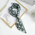 Detailed close-up view of the dark green silk scarf featuring stylish white polka dots and borders. - Dark Green