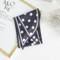 Detailed close-up shot of an elegant black silk scarf featuring classic white polka dots. - Black