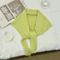 Primer plano de bufanda triangular de punto verde amarillo, chal de invierno acogedor. - Verde amarillento