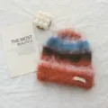 Primo piano dettagliato della texture accogliente del berretto invernale in mohair. - Cappello / Caffè