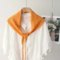 Détail de châle triangulaire en tricot orange, accessoire élégant pour femmes, tissu doux. - Orange
