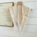 Detailaufnahme des cremefarbenen Strick-Dreiecktuchs mit feinen strukturierten Mustern. - Beige