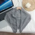 Closeup of gray knit triangular scarf, soft textured fabric detail for autumn and winter style. - Gray