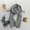 Cozy grey knitted winter scarf hanging on hanger, soft texture, warm everyday neckwear style. - 156x14cm / Gray
