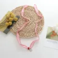 Delicate pink fabric ribbon choker necklace with small pendant and red bead detail. - Pink