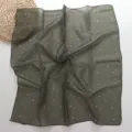 Detailed view of the dark green polka dot small square scarf showing fabric and pattern. - Army Green