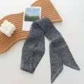 Detail view of a chic black and grey long ribbon scarf styled with minimalist wooden tray. - 01#-Cashew Pattern Scarf
