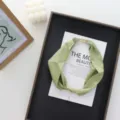 Detail shot of lightweight green silk scarf with magnetic clasp and pearl pendant for women. - 52x6cm / Green
