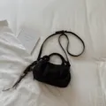 Black suede dumpling bag with knotted handle and strap, stylish minimalist design for daily use. - Black With Pendant