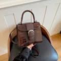 Vintage crocodile embossed patent leather handbag with top handle and stylish silver buckle. - Brown