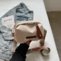 Casual offwhite nylon crossbody schoudertas schelpmodel met brede band en leeraccent. - Broken Wit