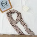 Primo piano di un foulard sottile vintage con pois e righe per un look chic ed elegante. - Versione Estesa / Beige Caffè
