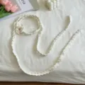 Detailansicht eines weißen handgehäkelten dünnen Schals mit süßem Blumenakzent, Flatlay. - Weiß
