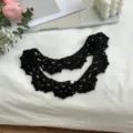 Close-up of black handmade crochet fake collar with delicate texture and pearl detail. - Black