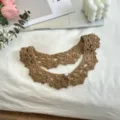 Close-up detail of the handmade brown crochet false collar with delicate hollow floral pattern. - Coffee