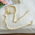 Nahaufnahme des handgemachten gestrickten Blumen-Schals mit feiner Häkelstruktur. - Beige