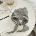 Vista dettagliata del foulard triangolare con stampa floreale grigia e orlo ondulato - Grigio