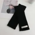 Black knit fingerless gloves detail view, soft wool wrist warmer accessory closeup. - 24*9 / Black