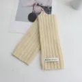 Detailed view of beige ribbed knit wool fingerless gloves with brand label, cozy warm wrist. - 24*9 / Beige