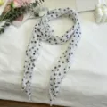 Detailweergave van de witte stippensjaal met een elegant 3D stoffen bloemaccent. - Witte & Zwarte Stippen