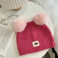 Detailed close-up of cute pink knitted beanie with fluffy pom-poms and front brand label. - 21x25cm (Size Without Ears) / Rose Red