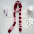 Detailed shot of Y2K pink dark red striped knit scarf, trendy long narrow scarf accessory. - Pink