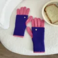 Detail view of the colorful knitted fingerless gloves showing soft wool texture and cute metal button. - One Size / Finger Style / Purple Pink