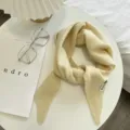 Λεπτομέρεια από απαλό μπεζ πλεκτό τριγωνικό κασκόλ σε μινιμαλιστικό τραπέζι παρουσίασης. - Μπεζ / Ένα μέγεθος