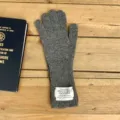 Detailed view of dark grey wool knit winter gloves with brand patch on wooden background. - 30*10cm / Dark Gray