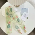 Primer plano detallado de ribete de encaje bordado con flores rosas y hojas verdes. - Bufanda de Seda 2
