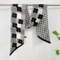 Detailed view of black and white floral houndstooth ribbon scarf, elegant neck wrap. - Clover 2